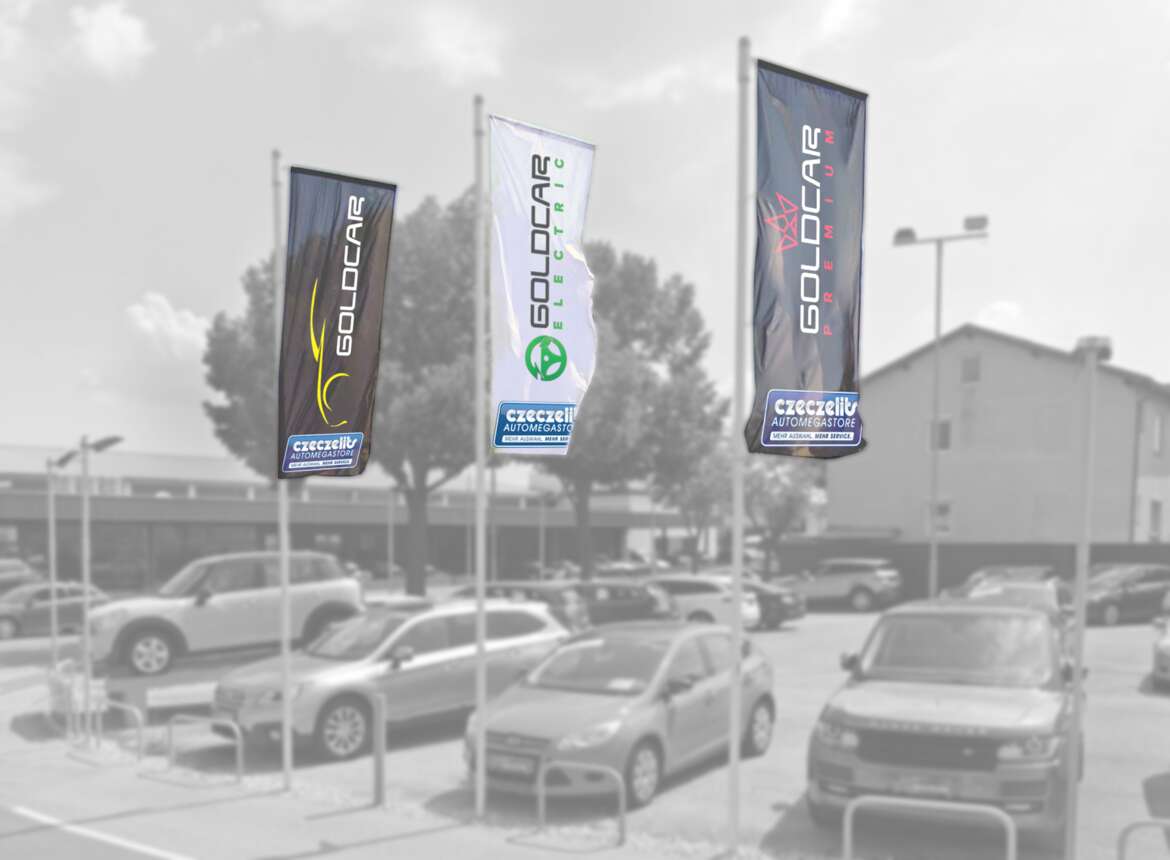 Fotoretusche von drei Goldcar Fahnen am Parkplatz mit den neuen Logos